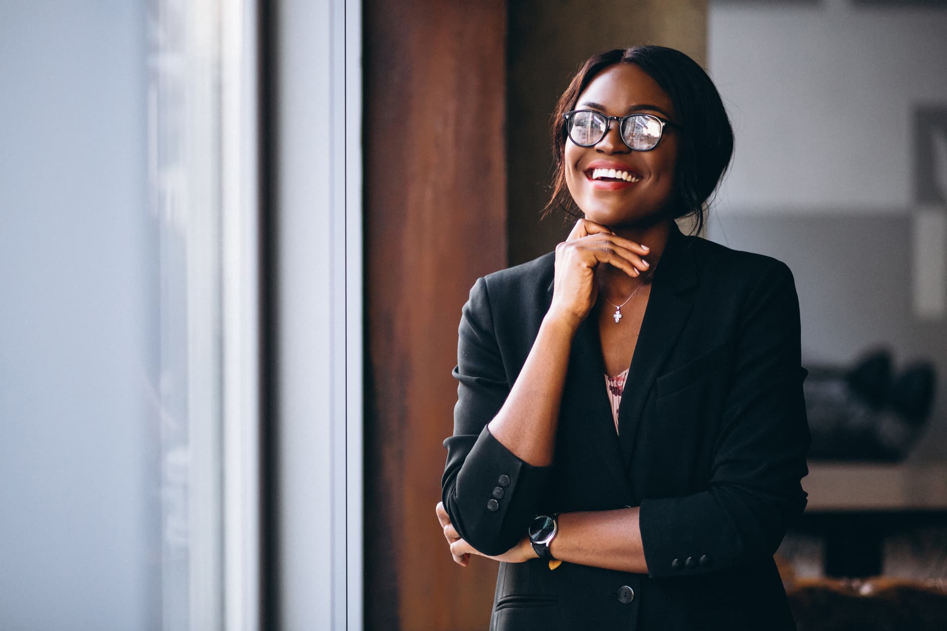 Smiling businesswoman standing by a window in a modern office